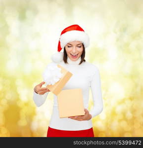 christmas, x-mas, winter, happiness concept - surprised woman in santa helper hat with gift box