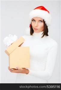 christmas, x-mas, winter, happiness concept - suspicious woman in santa helper hat with gift box