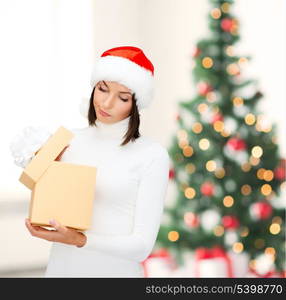 christmas, x-mas, winter, happiness concept - suspicious woman in santa helper hat with gift box