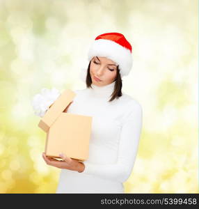 christmas, x-mas, winter, happiness concept - suspicious woman in santa helper hat with gift box