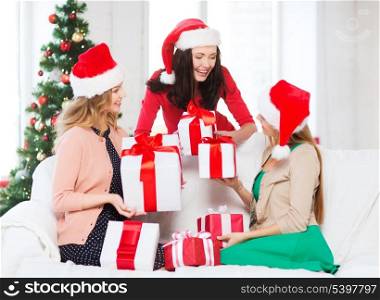 christmas, x-mas, winter, happiness concept - three smiling women in santa helper hats with many gift boxes