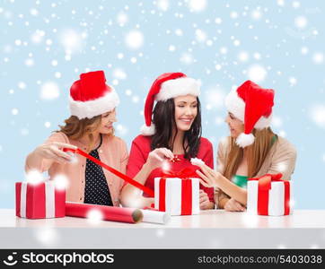 christmas, x-mas, winter, happiness concept - three smiling women in santa helper hats with gift boxes