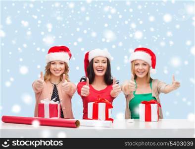 christmas, x-mas, winter, happiness concept - three smiling women in santa helper hats with gift boxes