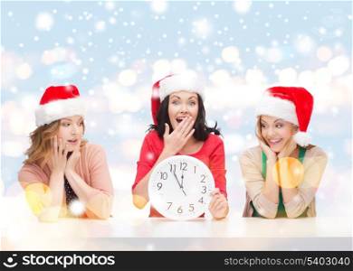 christmas, x-mas, winter, happiness concept - three smiling women in santa helper hats with clock showing 12