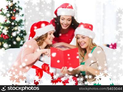 christmas, x-mas, winter, happiness concept - three smiling women in santa helper hats with card and many gift boxes