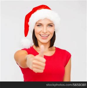 christmas, x-mas, winter, happiness concept - woman in santa helper hat showing thumbs up