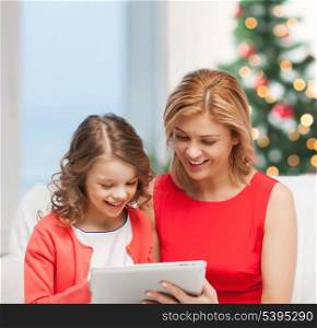 christmas, x-mas, winter, happiness, modern technology concept - mother and daughter with tablet pc