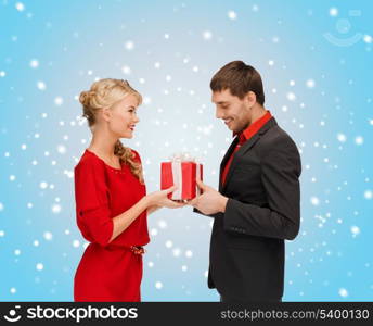 christmas, x-mas, winter, valentine&#39;s day, birthday, happiness, couple concept - smiling woman and man with gift box