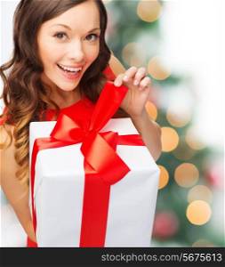christmas, xmas, celebration concept - smiling woman in red dress with gift box