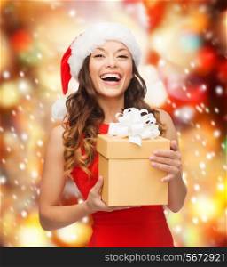 christmas, xmas, new year, happiness concept - laughing asian woman in santa helper hat with gift box