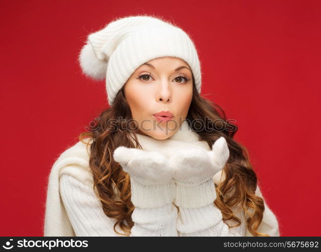 christmas, xmas, people, happiness concept - happy woman in winter clothes blowing on palms