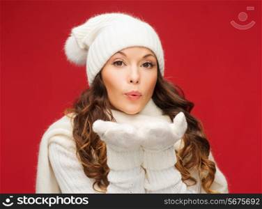 christmas, xmas, people, happiness concept - happy woman in winter clothes blowing on palms