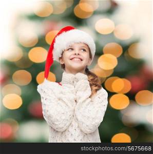 christmas, xmas, winter and happiness concept - dreaming girl in santa helper hat