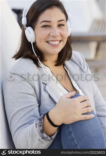 chubby girl listening music outdoors