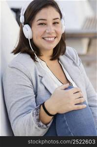 chubby girl listening music outdoors