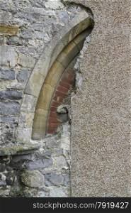 Church arch, partially obscured by modern rendering. St Michael the Archangel, Lyme Regis, Dorset, England, United Kingdom.