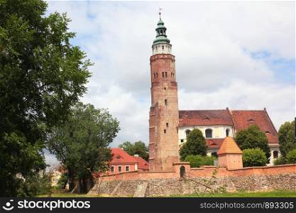 Church behind defence city wall with tower in Wschowa Poland