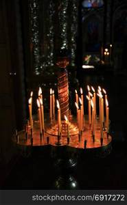 church candles. church candles on candlesticks in church burn in darkness