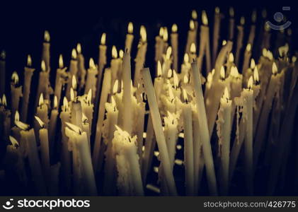 Church candles lit, detail of illumination and flame, belief and faith