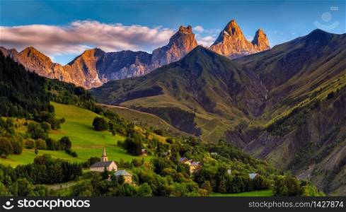 church in a village in the french alps with mountains 3000 meters high. Green meadows in spring