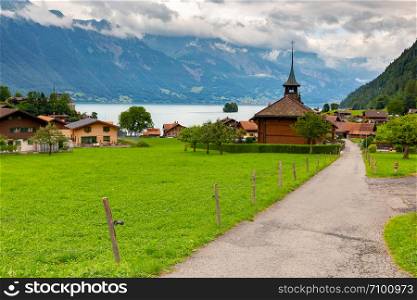 Church in the traditional Swiss village of Iseltwald on the famous lake Brienz. Switzerland.. The Swiss village of Iseltwald on the famous lake Brienz.