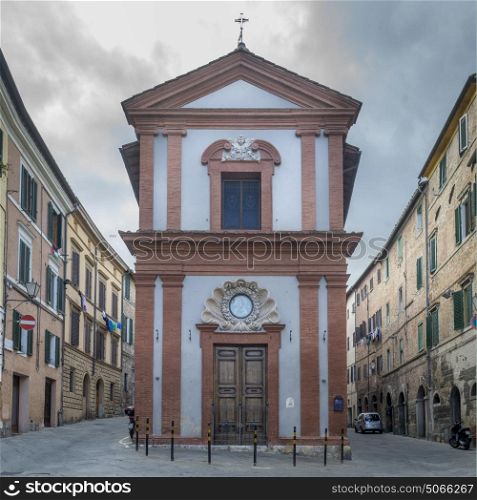 Church on street amidst buildings, Siena, Tuscany, Italy