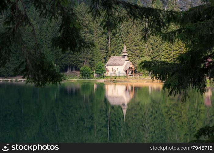 Church reflected at the lake. Lago di Braies, Italy