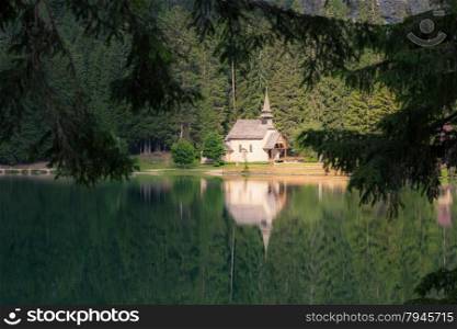 Church reflected at the lake. Lago di Braies, Italy