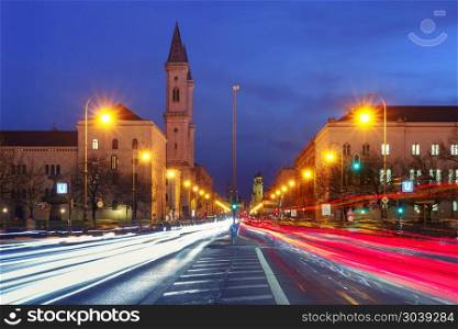 Church St. Louis at night, Munich, Germany. Ludwigstrasse avenue with light tracks and Church St. Louis, called Ludwigskirche, during evening blue hour in Munich, Germany
