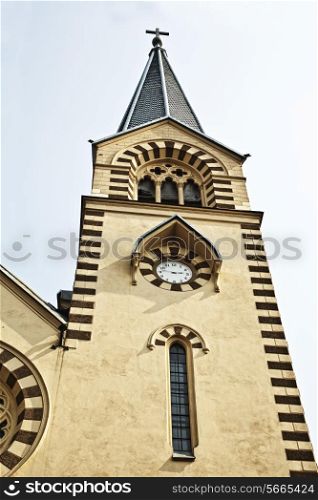 church tower with spire, cross and clock