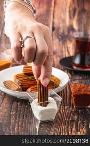 Churros with curry, olives and tomato paste on wooden table with Turkish tea