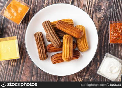 Churros with curry, olives and tomato paste on wooden table with Turkish tea