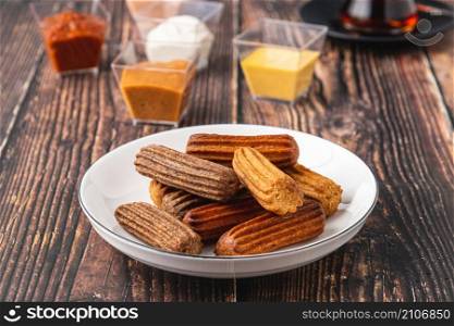 Churros with curry, olives and tomato paste on wooden table with Turkish tea