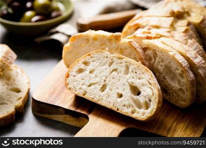 Ciabatta bread sliced on a board, top view