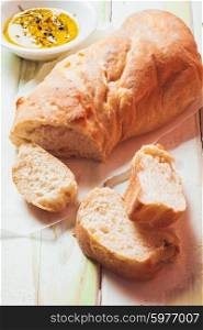 Ciabatta - italian bread with olive oil and spices over wooden table. Ciabatta