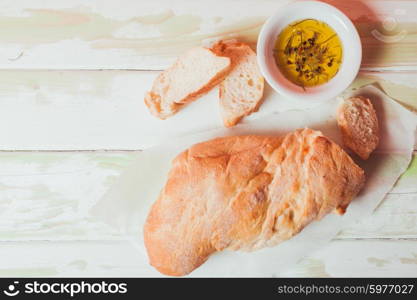 Ciabatta - italian bread with olive oil and spices over wooden table. Ciabatta