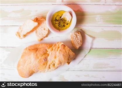 Ciabatta - italian bread with olive oil and spices over wooden table. Ciabatta italian bread