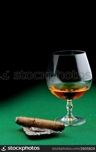 Cigar and drink on green close up