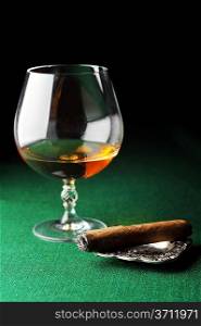 Cigar and drink on green close up