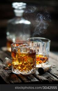 Cigar and glass with whiskey with ice cubes. Two glasses of whiskey