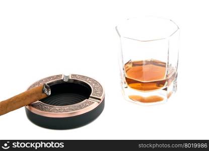 cigar in ashtray and cognac on white