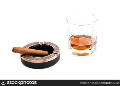 cigar in ashtray and cognac on white closeup