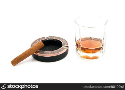 cigar in ashtray and glass of cognac on white
