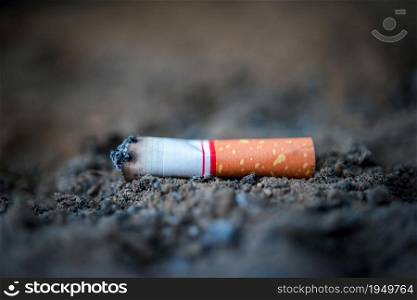 Cigarette burning in outdoors ashtray from smoker addictive nicotine unhealthy and danger concept. Cigarette burning from smoker addictive nicotine