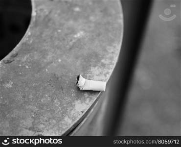 Cigarette butt waste in black and white. Cigarette butt waste on a metal surface in black and white