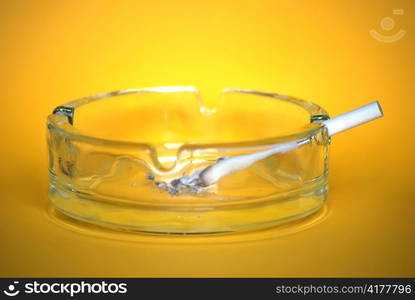 cigarette in ash tray on yellow background