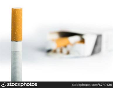 Cigarette on the foreground and many cigarettes on a background