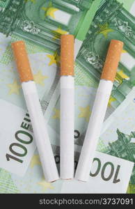 cigarettes lying on the bills of one hundred euros