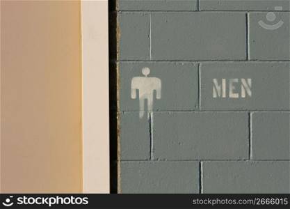 Cinder block wall detail with male bathroom signage