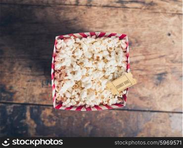 Cinema concept of popcorn and movie ticket on a wooden table